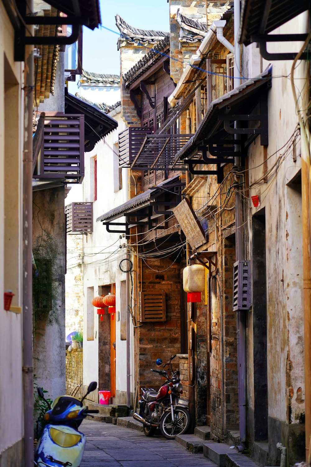 a narrow street with a motorcycle parked on the side of it