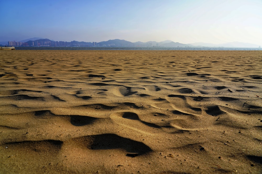 a sandy beach with mountains in the distance