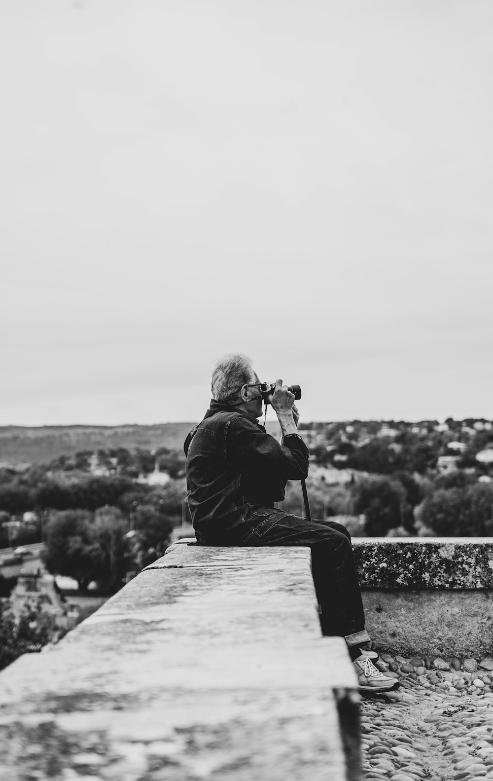 a person sitting on a ledge with a camera