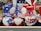A display of decorative gnome figurines wearing patriotic attire, each featuring a long white beard and oversized hats in red, white, and blue adorned with stars. They hold various signs, such as 'I Love USA', 'Welcome', and other American-themed imagery. The collection appears to be for sale, as indicated by a price tag visible below.