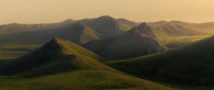 Rolling hills of the Isle of Skye bathed in warm golden afternoon light.
