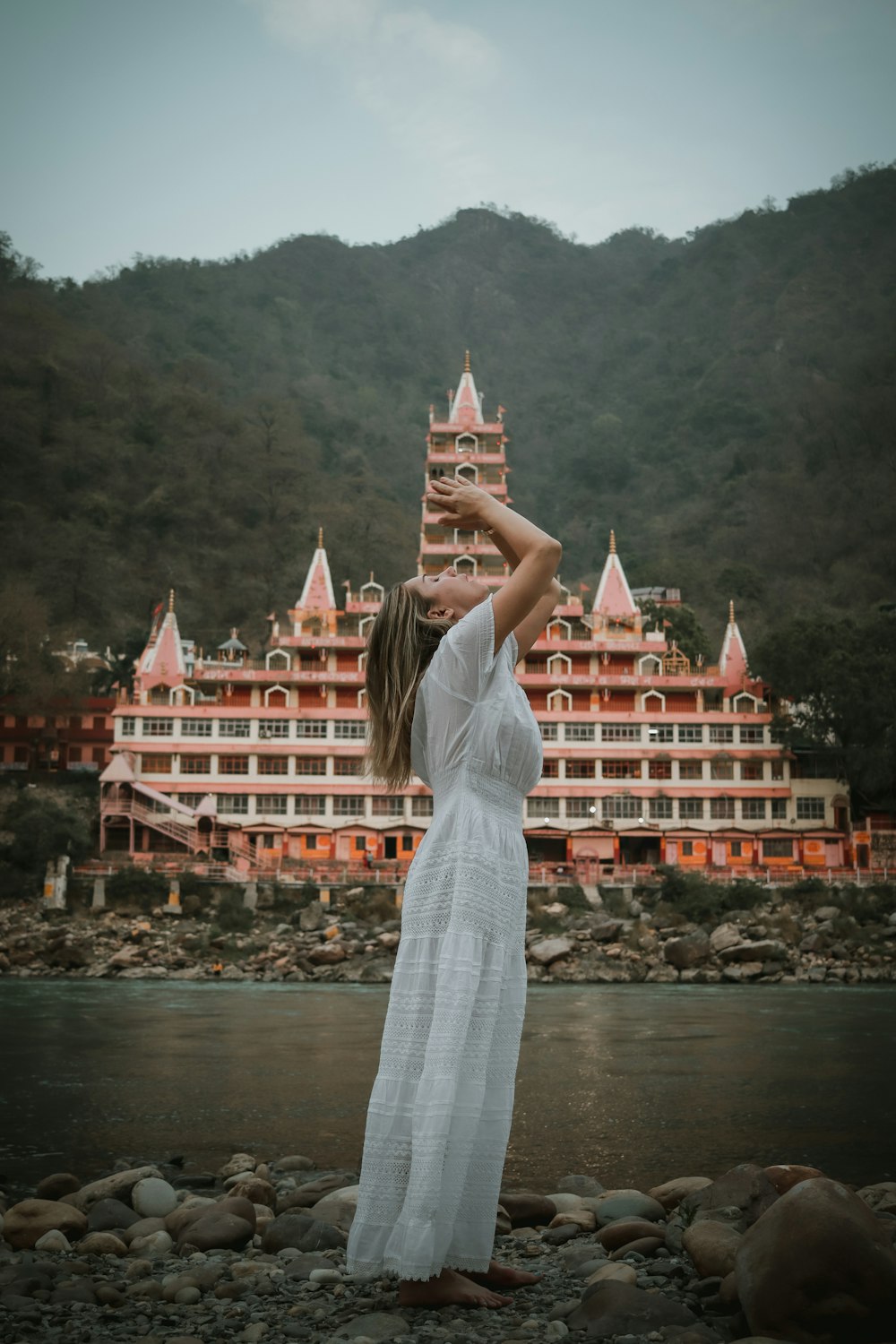 uma mulher com um vestido branco em frente a um grande edifício