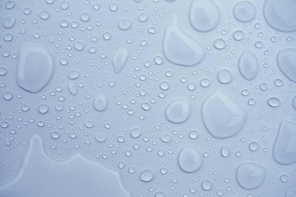 a close up of water droplets on a white surface