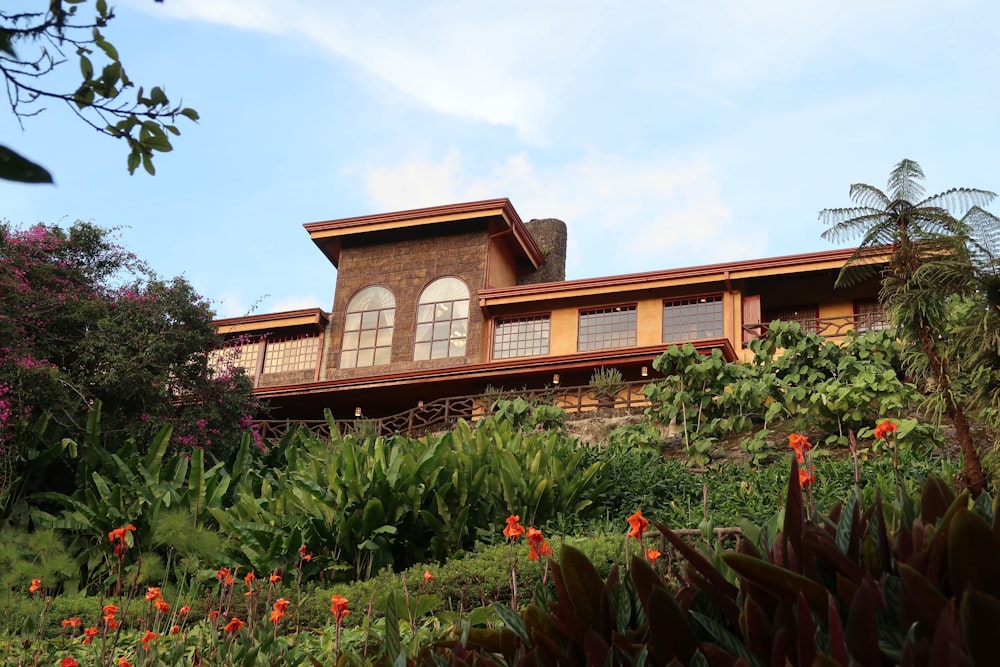 a house on a hill surrounded by trees and flowers