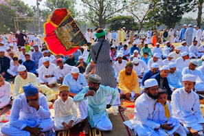 An outdoor event with banners of Gerakan Dakwah Kebangsaan and people interacting warmly