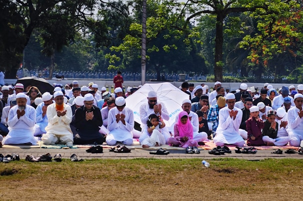 A heartfelt prayer session with community members gathered under a large tree.