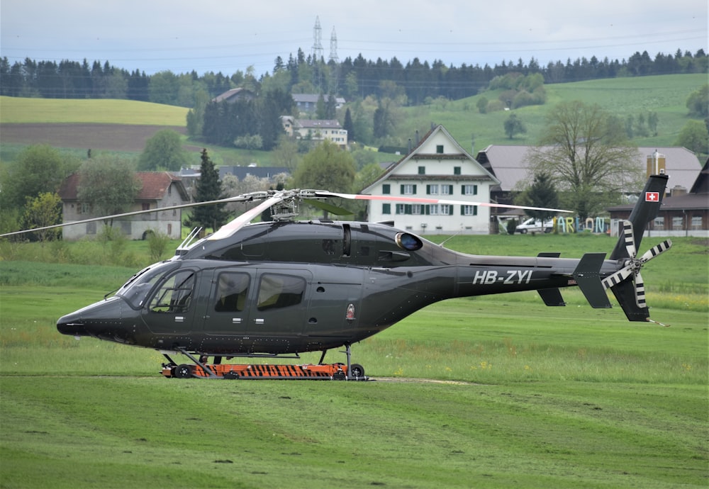 a helicopter sitting on top of a lush green field
