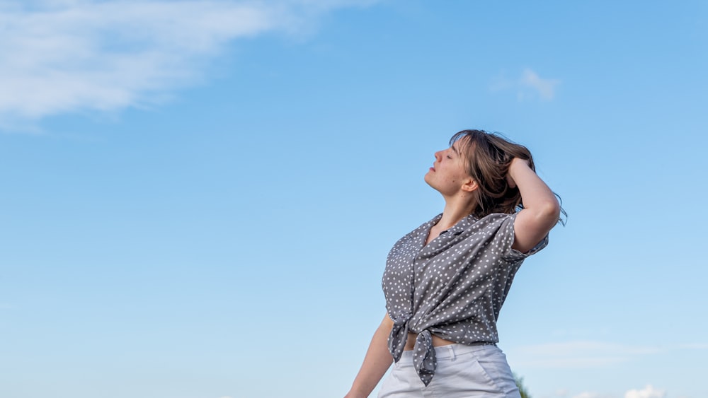 a woman standing in a field with a frisbee in her hand