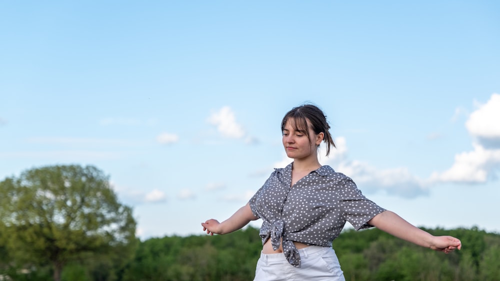 Una donna in piedi in un campo con le braccia tese