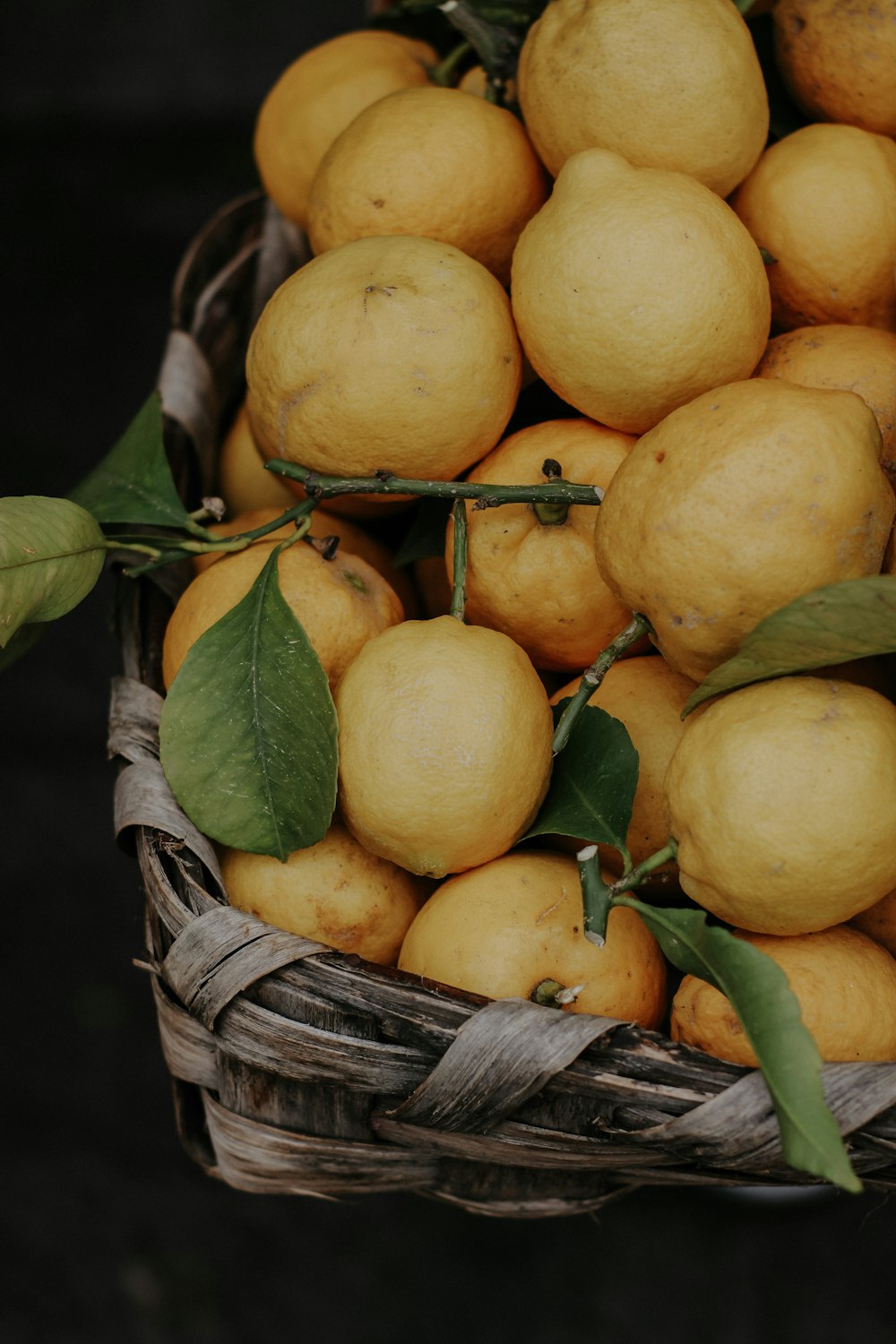 a basket filled with lots of yellow lemons