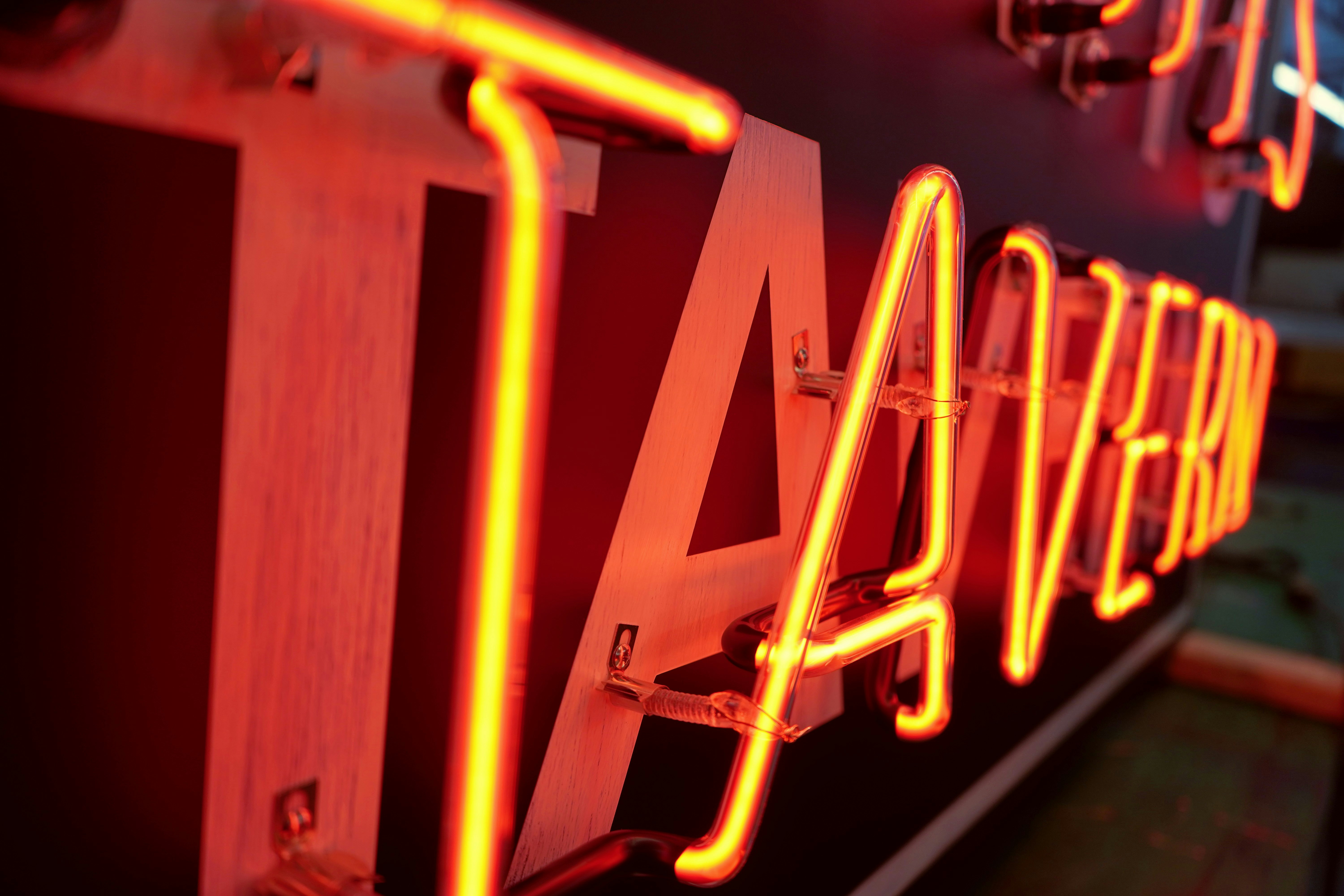 A neon sign that is on the side of a building photo – Free Neon Image ...