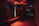 A dimly lit industrial escape room with neon green accents and rusty metal textures.
