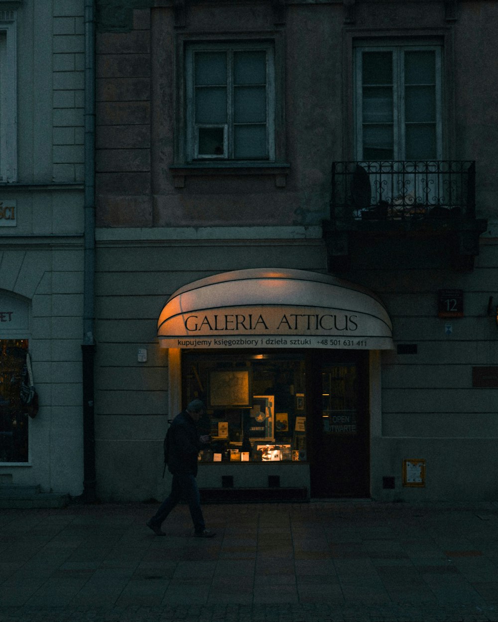 a man walking past a building at night