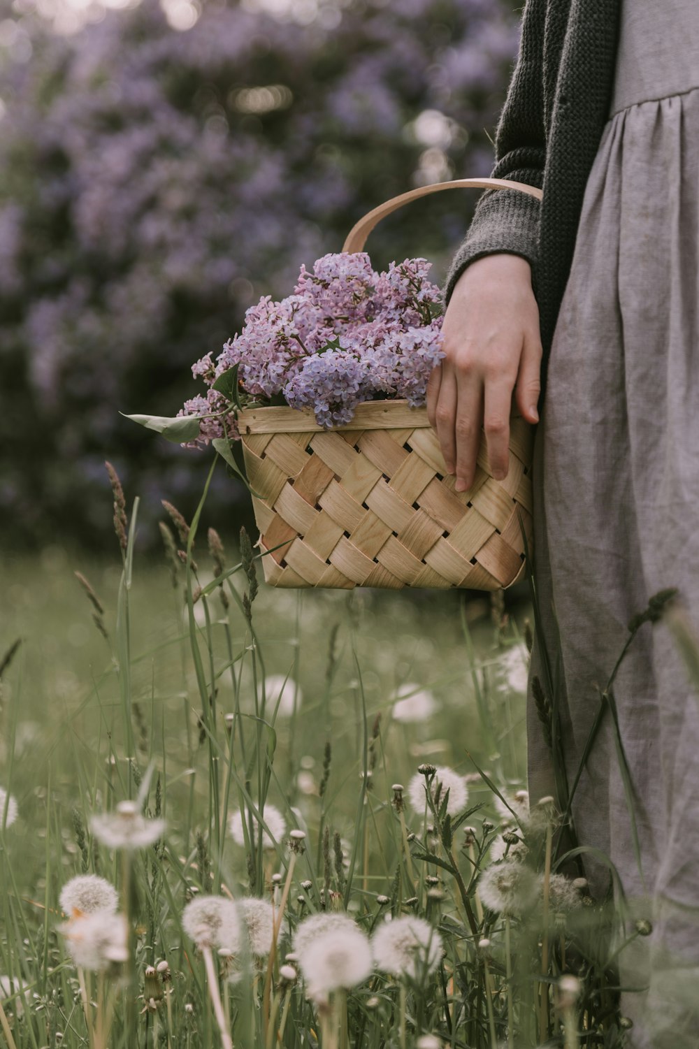 a person holding a basket with flowers in it