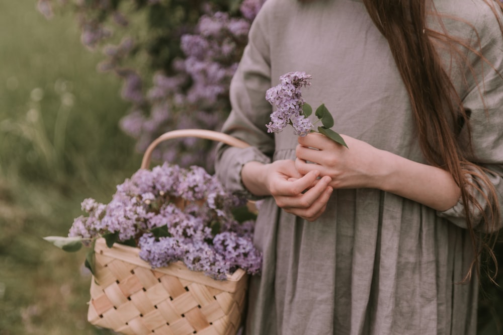 a woman holding a basket full of flowers