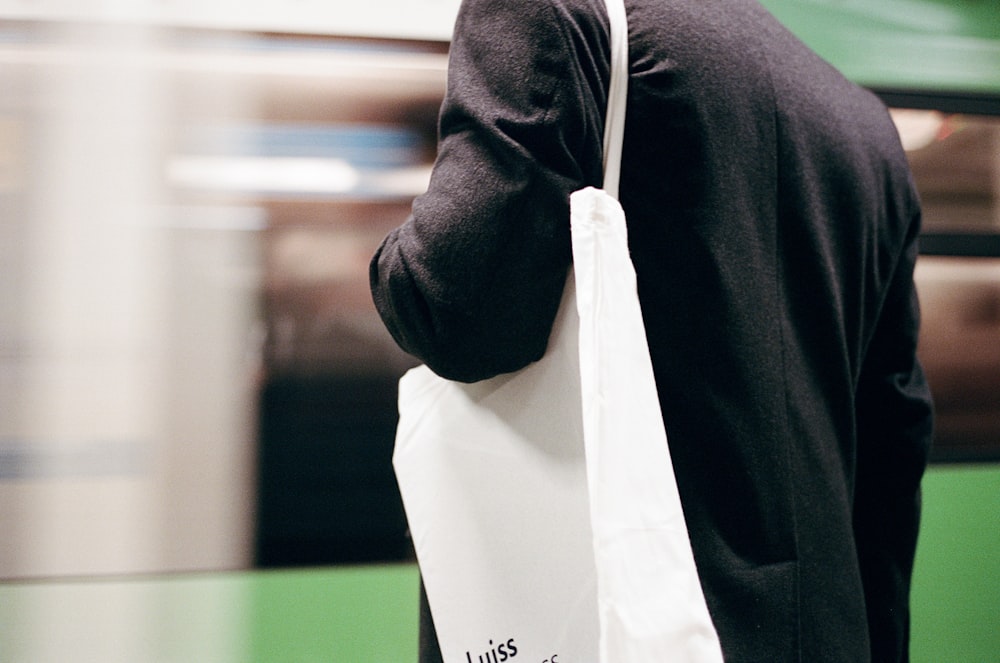 a man carrying a white bag on his back