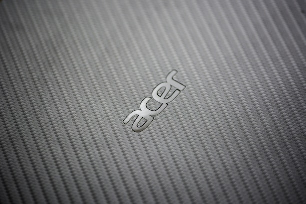 A close-up view of a textured, woven pattern surface with the metallic logo of a technology brand prominently displayed.