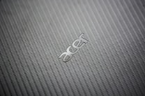 A close-up view of a textured, woven pattern surface with the metallic logo of a technology brand prominently displayed.