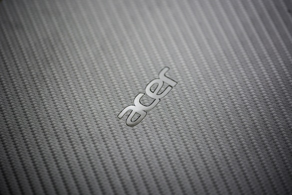 A close-up view of a textured, woven pattern surface with the metallic logo of a technology brand prominently displayed.