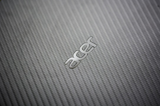 A close-up view of a textured, woven pattern surface with the metallic logo of a technology brand prominently displayed.