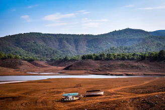 a couple of boats sitting on top of a dirt field