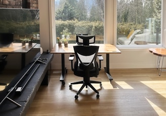 a chair sitting in front of a window next to a desk