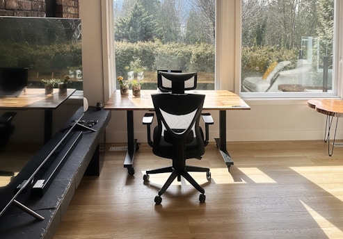a chair sitting in front of a window next to a desk