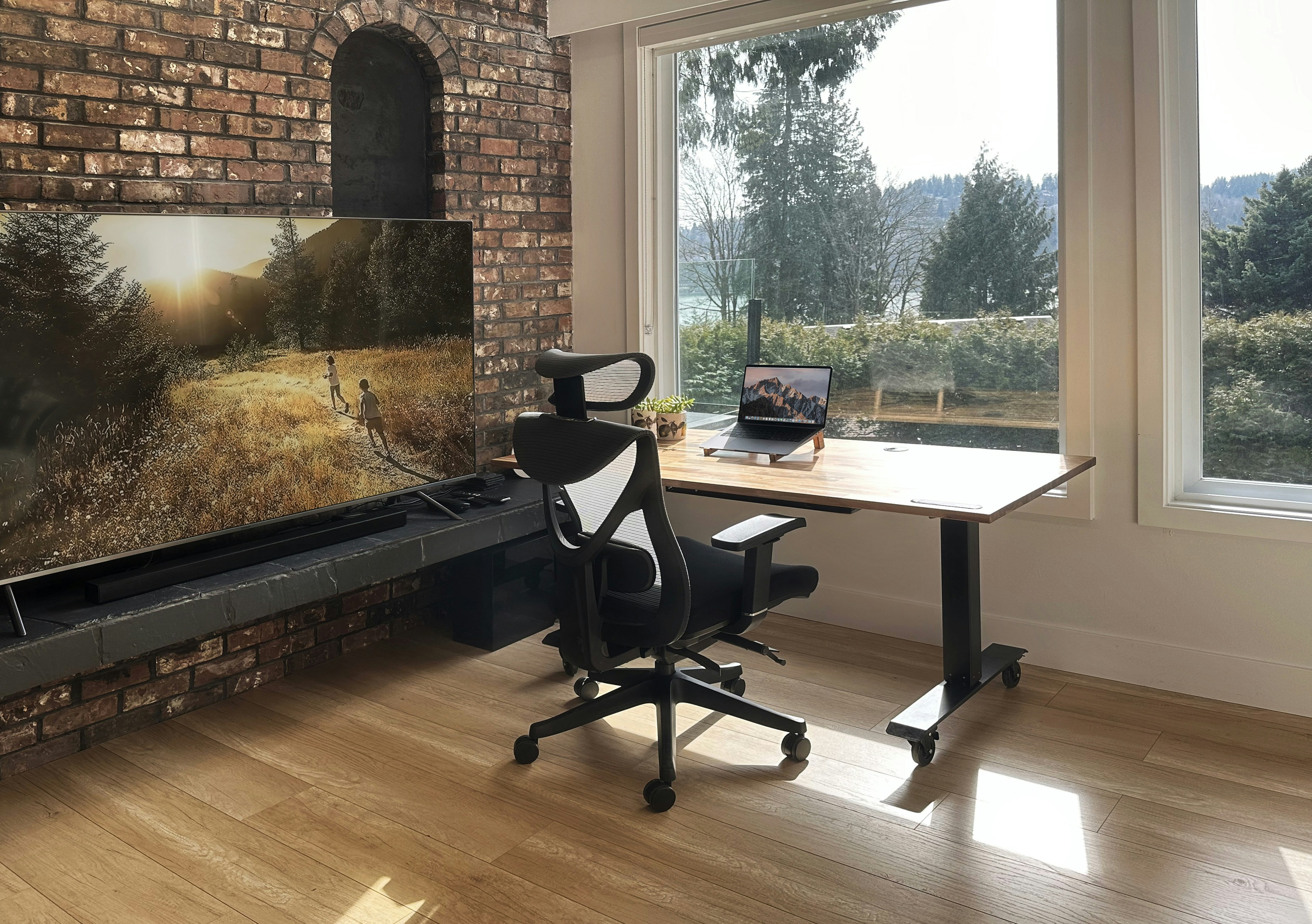 a desk with a chair and a television in a room