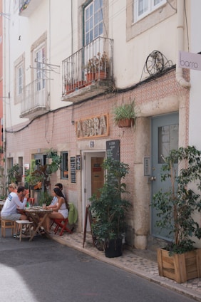 Cozy outdoor seating at a small piazza café with people enjoying drinks and conversation.