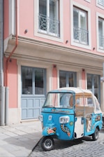 A vibrant blue and white Stransport bolero vehicle parked in an Indian market street.