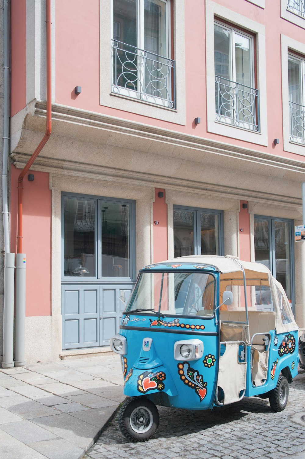 a small blue and white car parked in front of a building