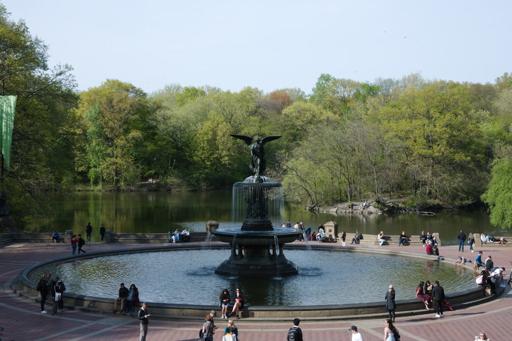 eine gruppe von menschen, die um einen brunnen stehen