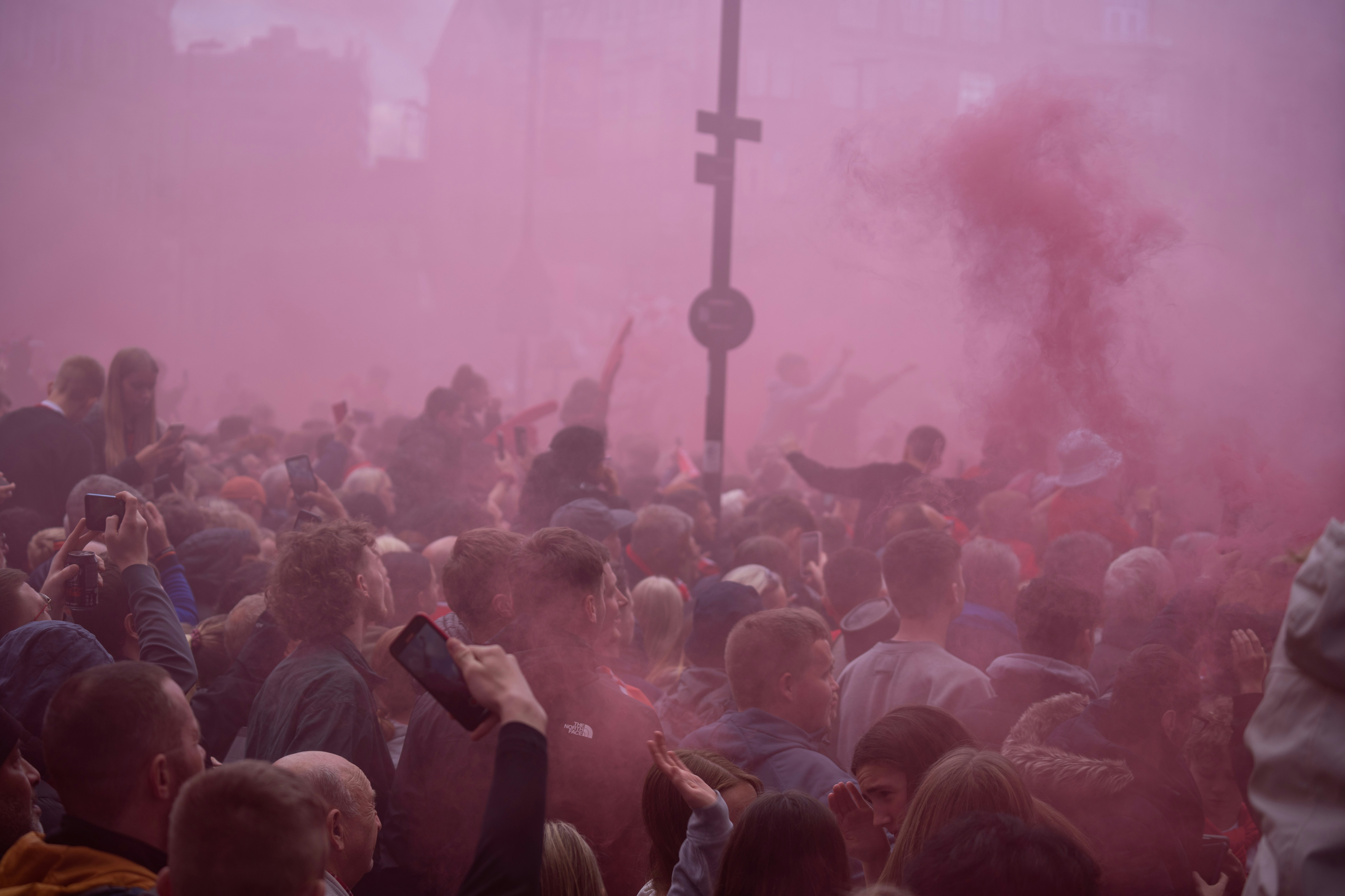 a crowd of people standing around a cross on a foggy day