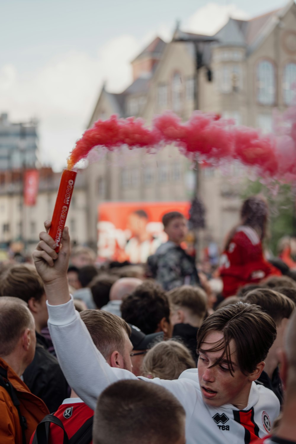 a crowd of people with red smoke coming out of their mouths