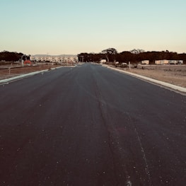 A newly paved road stretching through a growing neighborhood.