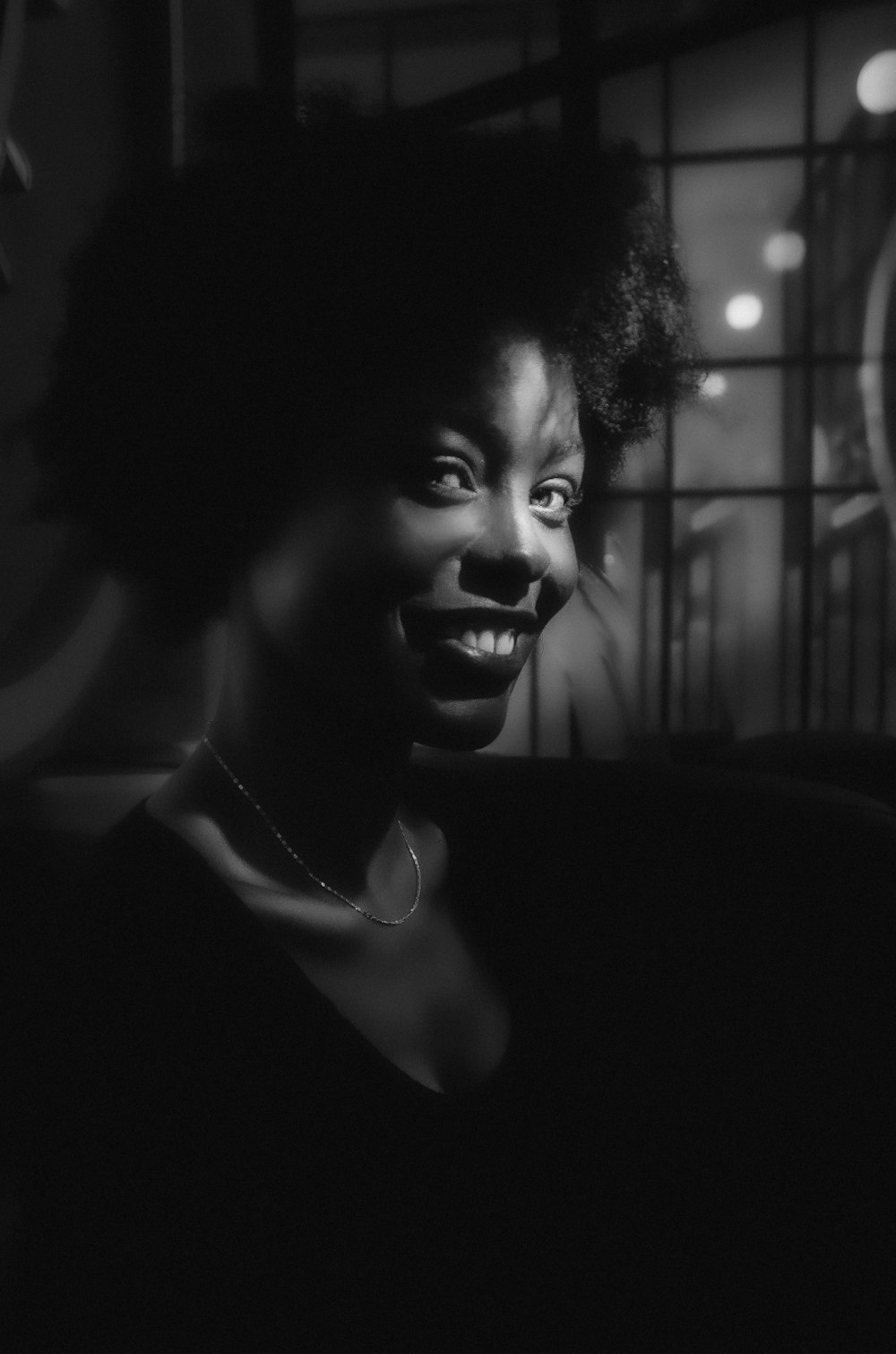 a black and white photo of a woman smiling