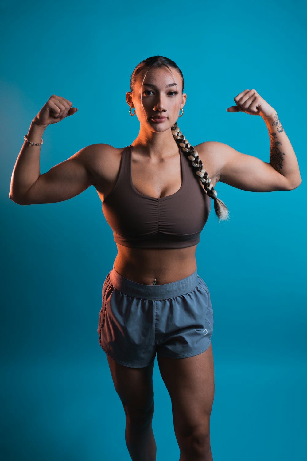 a woman in a sports bra top flexing her muscles