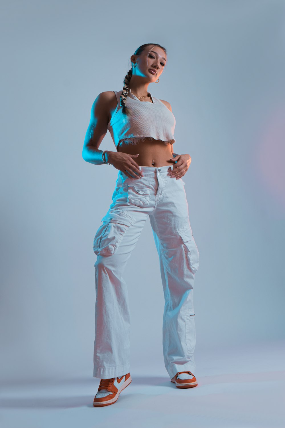 a woman in white pants and a crop top