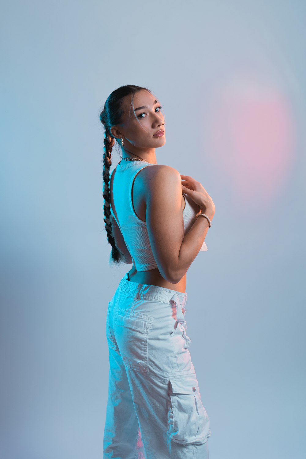 a woman with braids standing in front of a blue background