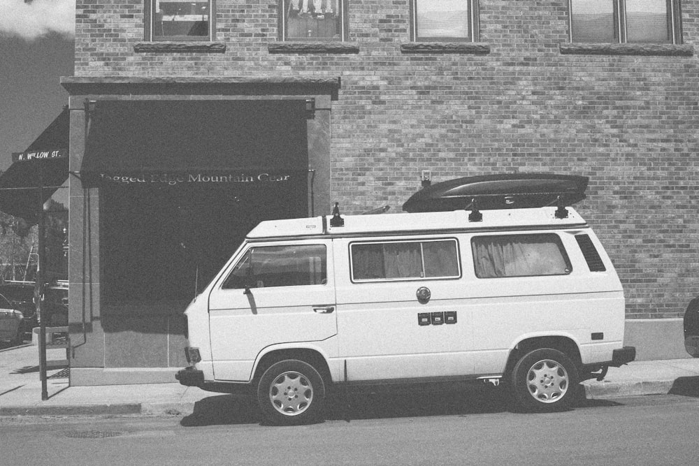 a white van parked in front of a brick building