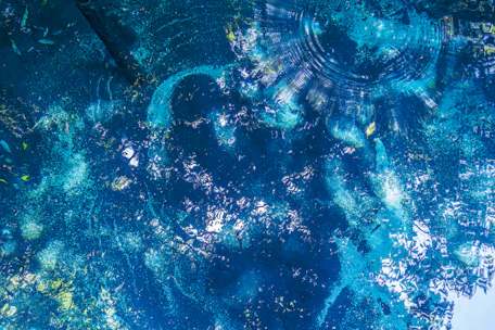 A deep blue Tides suit card shimmering with watery waves and subtle light reflections.
