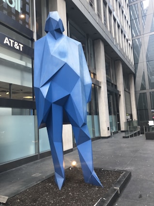 a sculpture of a blue bear in front of a building