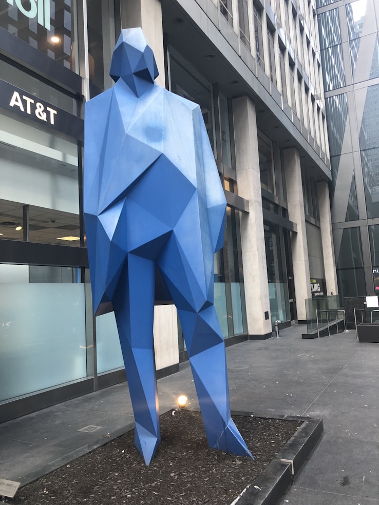 a sculpture of a blue bear in front of a building