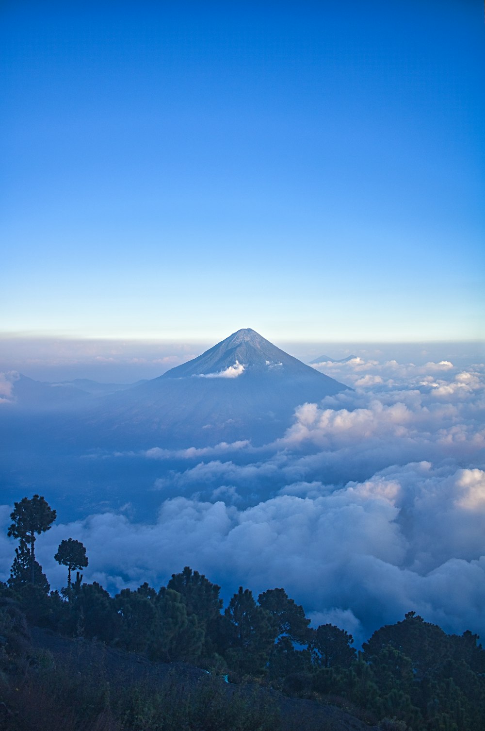 a view of the top of a mountain in the clouds