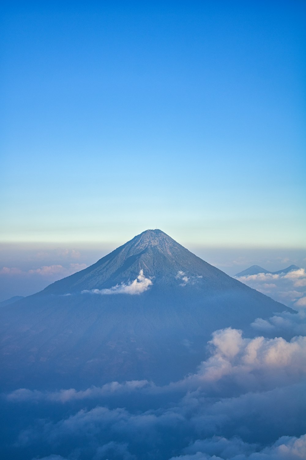 a view of the top of a mountain in the clouds