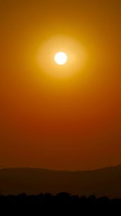 Close-up of a glowing sun with warm golden rays stretching across a clear sky.
