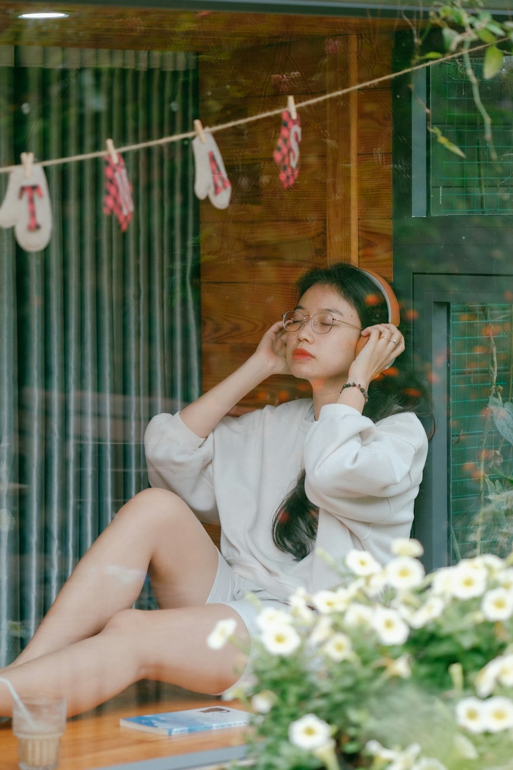 a woman sitting on a window sill talking on a cell phone