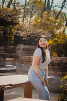 a woman is posing for a picture in front of a bench