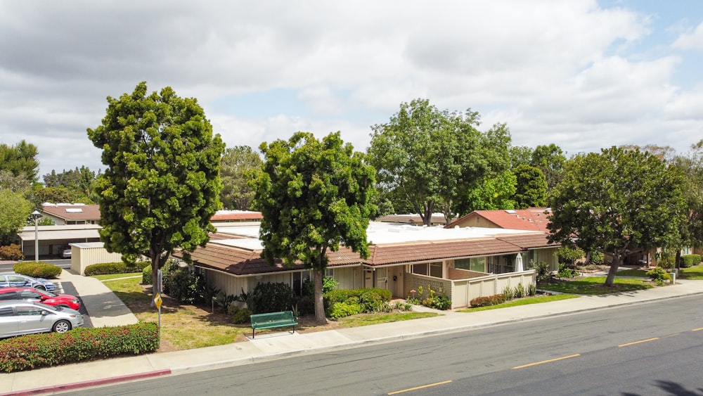 a street view of a house with cars parked in front of it