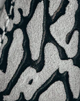 a close up of a black and white pattern on a wall Hand tufted rugs Kanha Universal Export